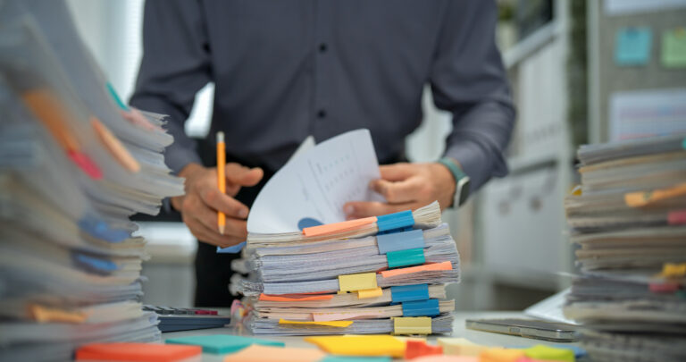 Why outsource accounting? stack of papers on desk