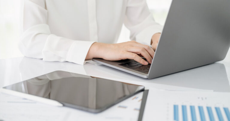 benefits of outsourcing accounting services. accountant using teblet and laptop