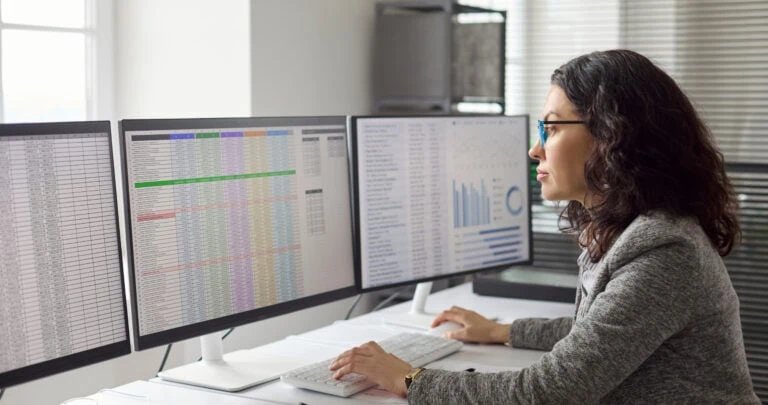 how to build an accounting system, woman looking at accounting spreadsheets and reports